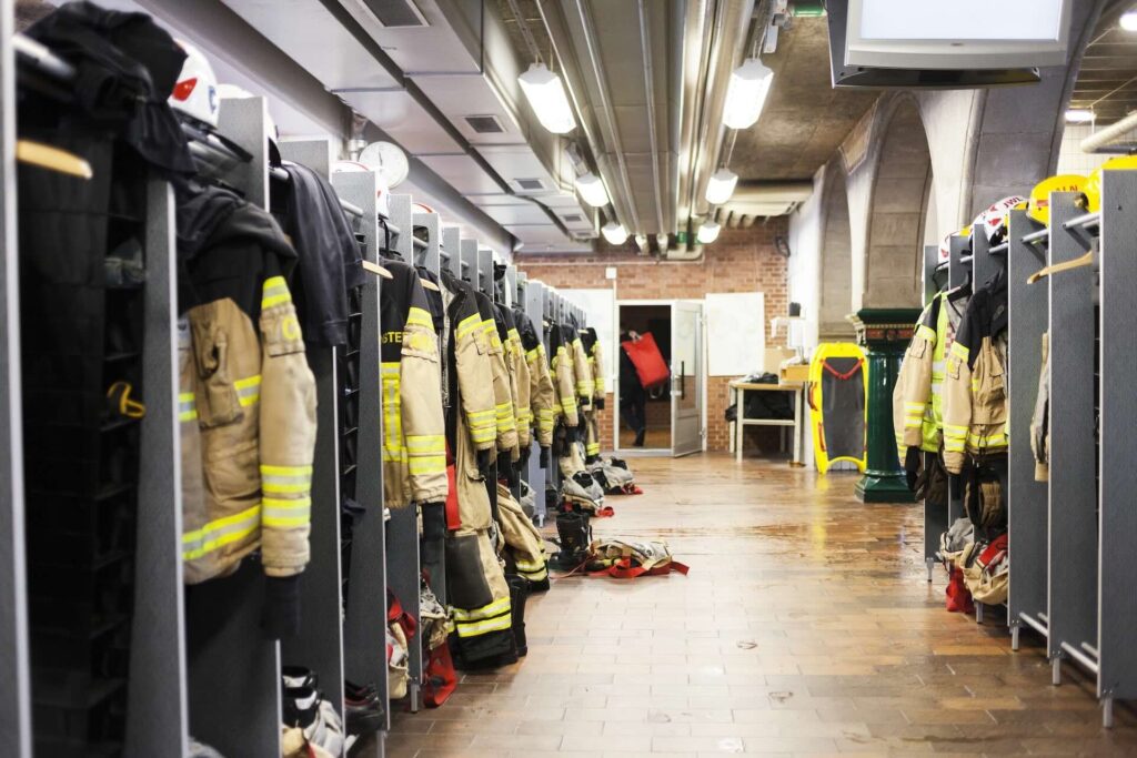 Firefighters jackets inside lockers inside a firefighter station.